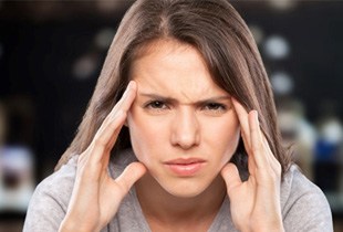 Frowning woman holding the sides of her face