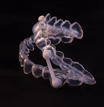 Side view of oral sleep appliance against dark background