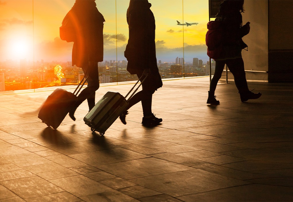 People with rolling bags at an airport