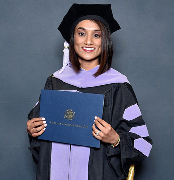 Doctor Jariwala holding dental school diploma at her graduation