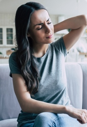 Woman in need T M J treatment holding neck in pain