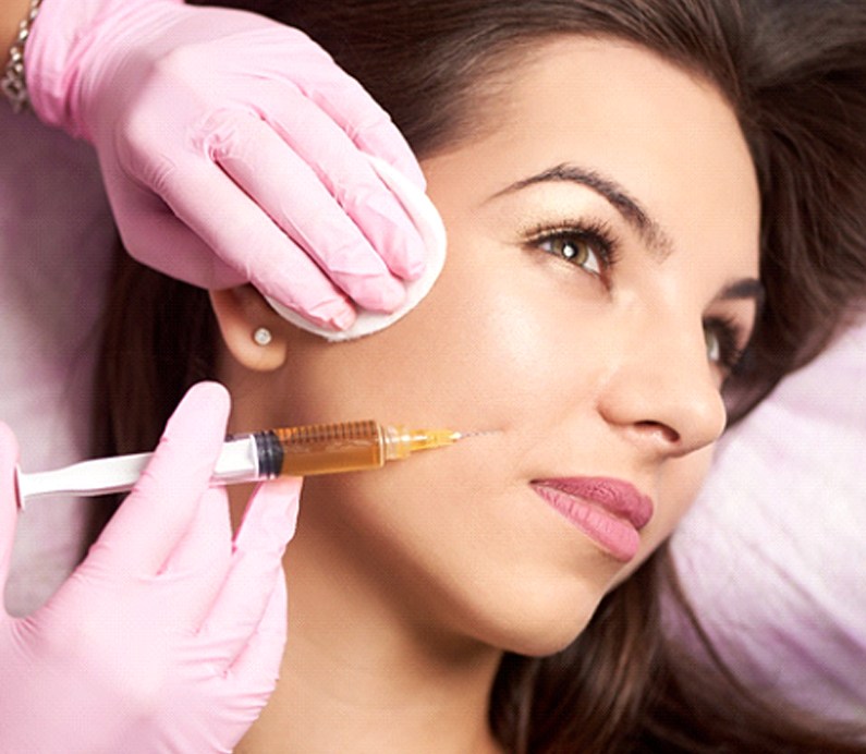 Woman turning head to receive Juvederm dermal fillers in Albuquerque