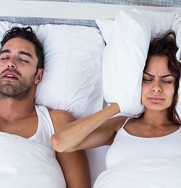 woman blocking ears because partner is snoring 