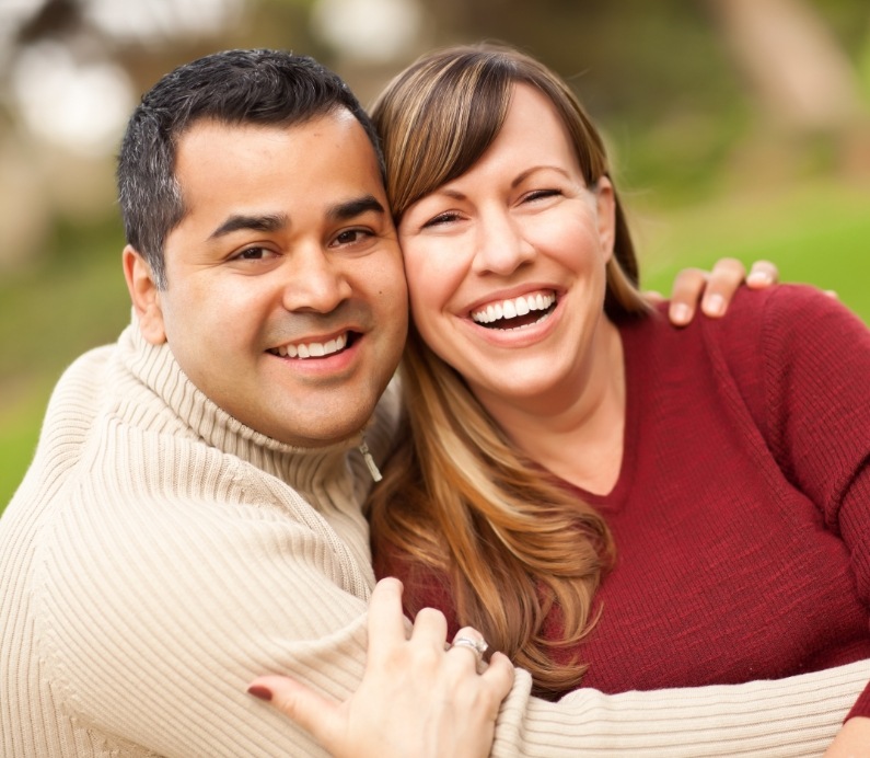 Man and woman laughing together after T M J therapy