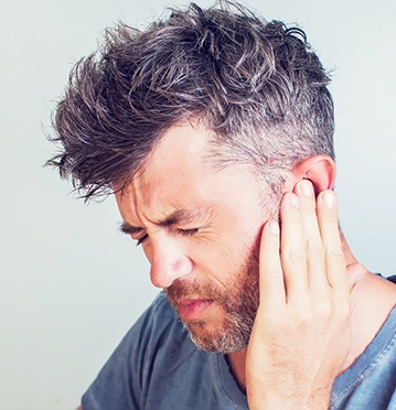 Man with ear pain and tinnitus from TMJ disorder