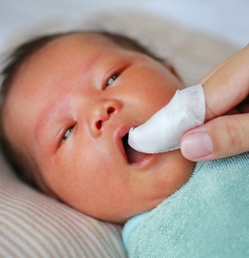 Dentist examining baby before lip and tongue tie treatment