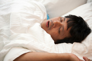 Man with sleep apnea snoring in bed