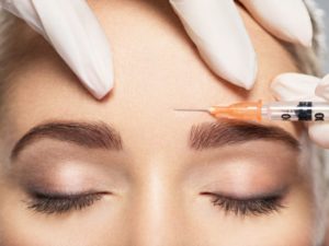 Woman receiving BOTOX injection between her eyebrows