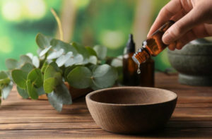 Drops of essential oil in wooden bowl