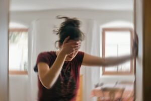 Woman leaning against a wall, experiencing vertigo 